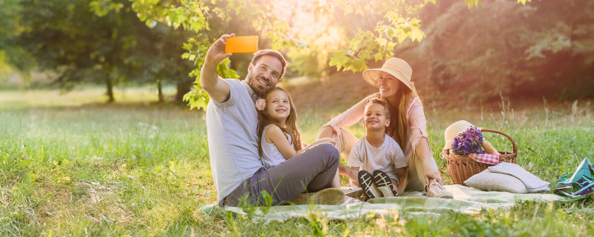 Handyvertrag Frühlingsangebote: Familie macht bei Picknick ein Selfie.