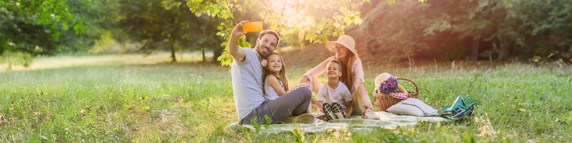 Handyvertrag Frühlingsangebote: Familie macht bei Picknick ein Selfie.