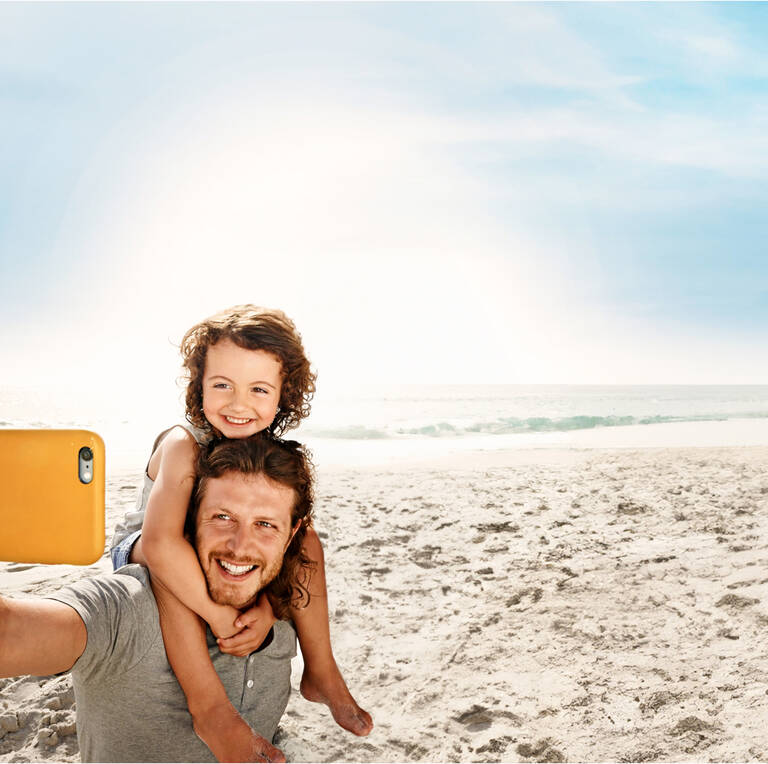 Eine Familie macht ein Selfie am Strand.