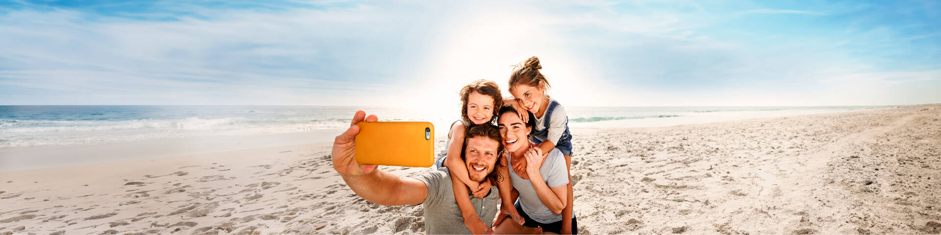 Eine Familie macht ein Selfie am Strand.