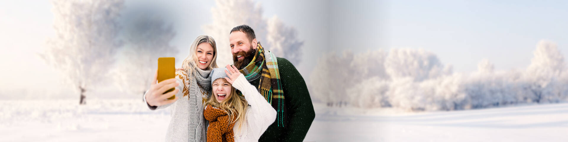 Familie macht mit ihrem Handy und günstigen Handyvetrag ein Selfie in der Winterlandschaft