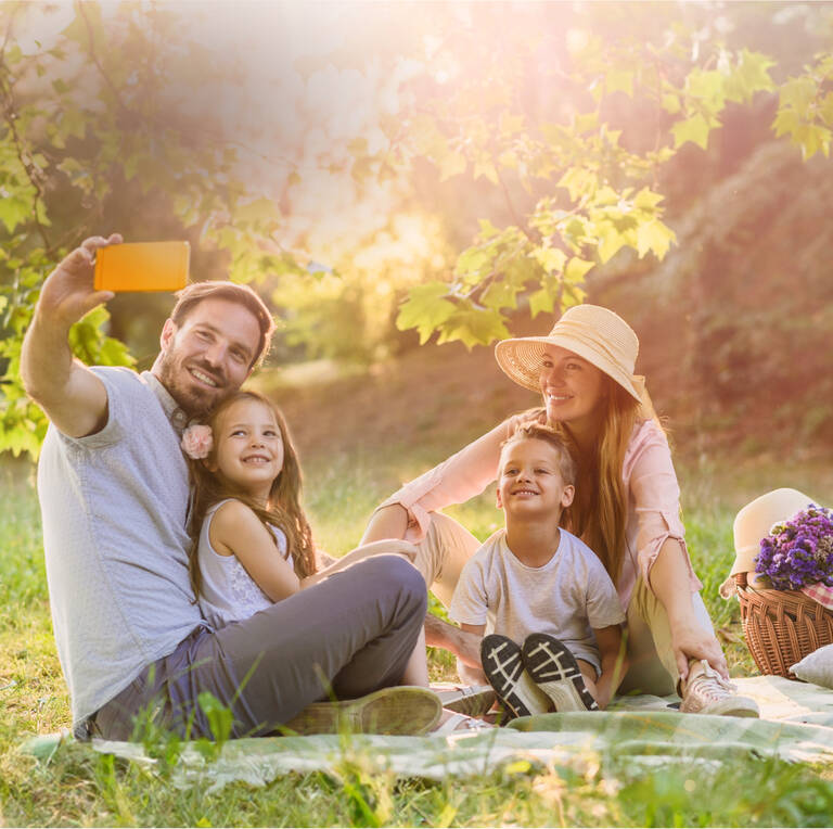 Handyvertrag Frühlingsangebote: Familie macht bei Picknick ein Selfie.