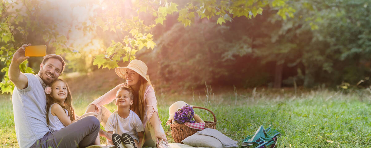 Handyvertrag Frühlingsangebote: Familie macht bei Picknick ein Selfie.