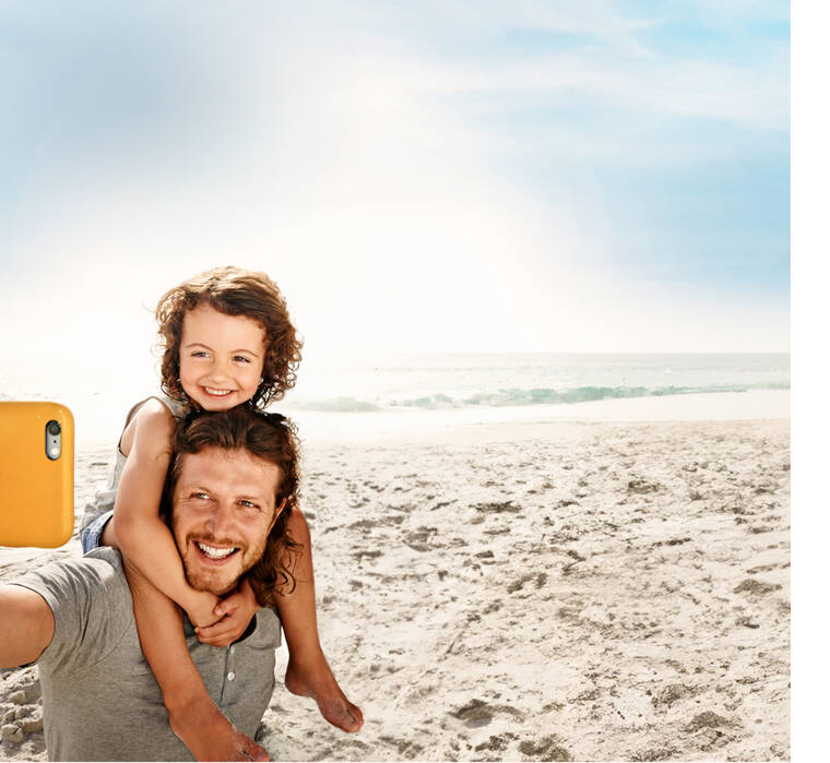 Eine Familie macht ein Selfie am Strand.