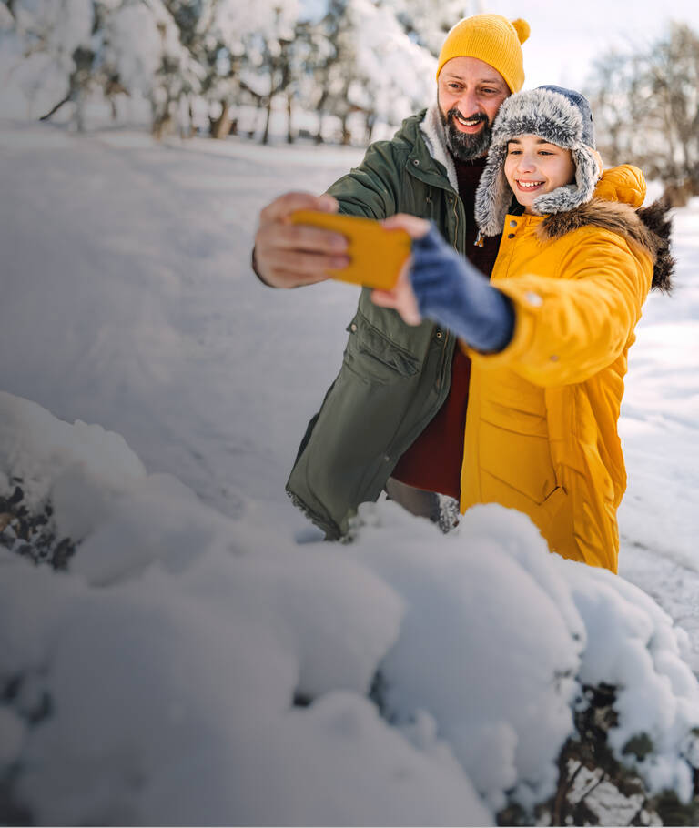 Unbegrenztes Datenvolumen: Vater und Kind in Winterlandschaft machen ein Selfie.